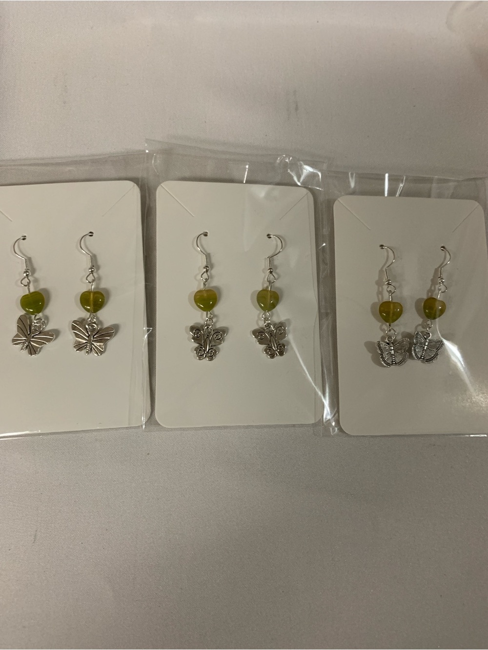 Silver Butterfly Drop Earrings with Olive Green Glass Heart Bead